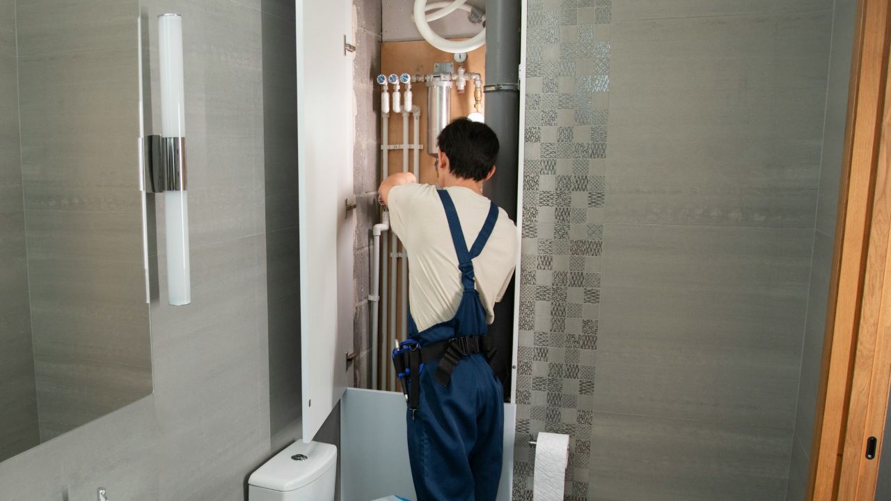 Plumber fixing pipes in a bathroom