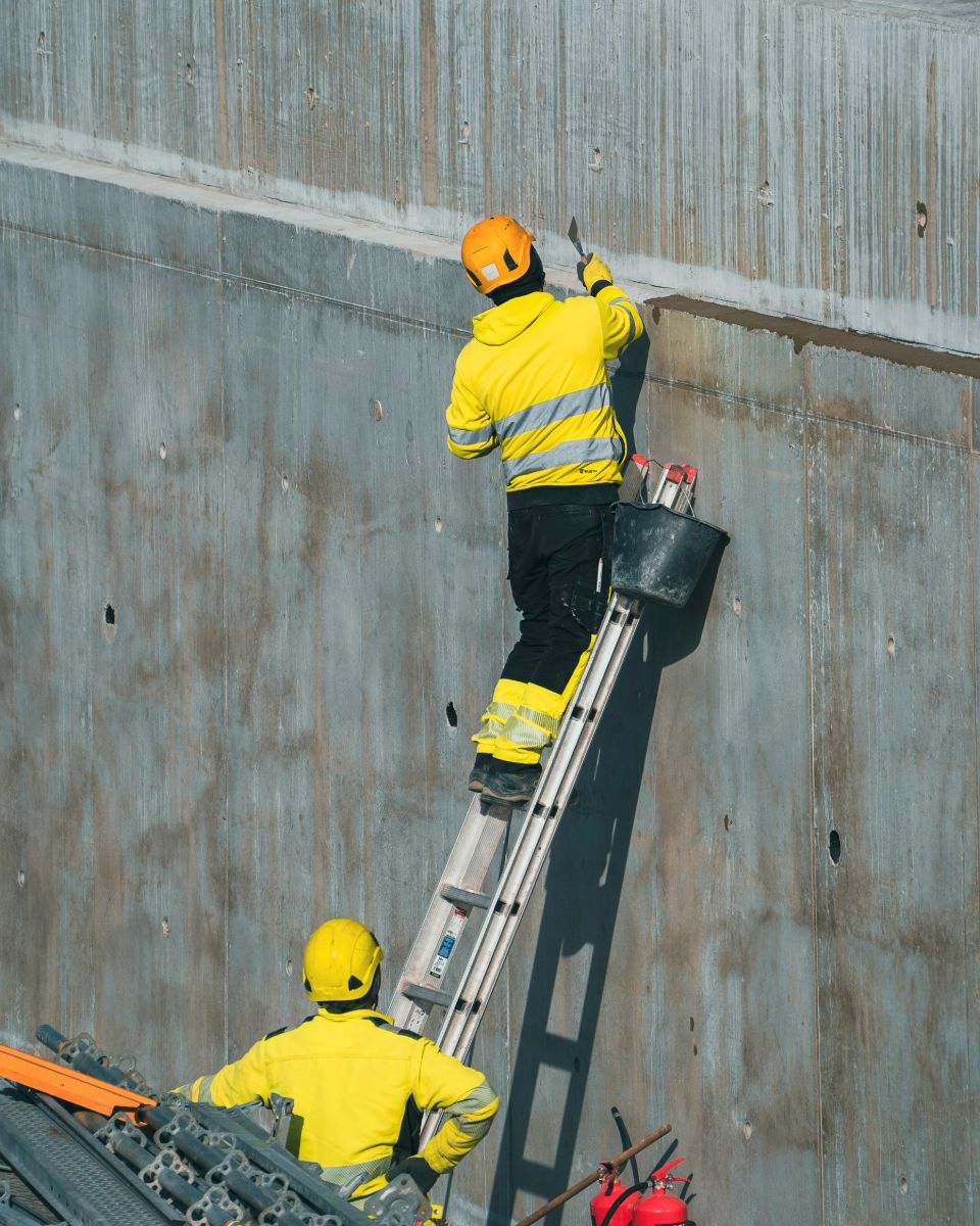 Construction workers at a concrete wall